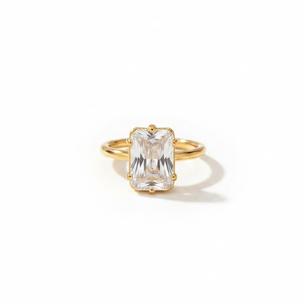 Gold ring with a large diamond on a beige fabric background